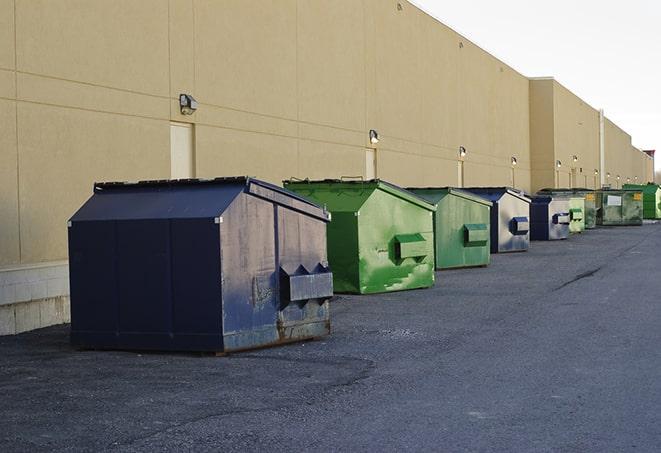 a construction worker disposing of debris into a dumpster in Avon